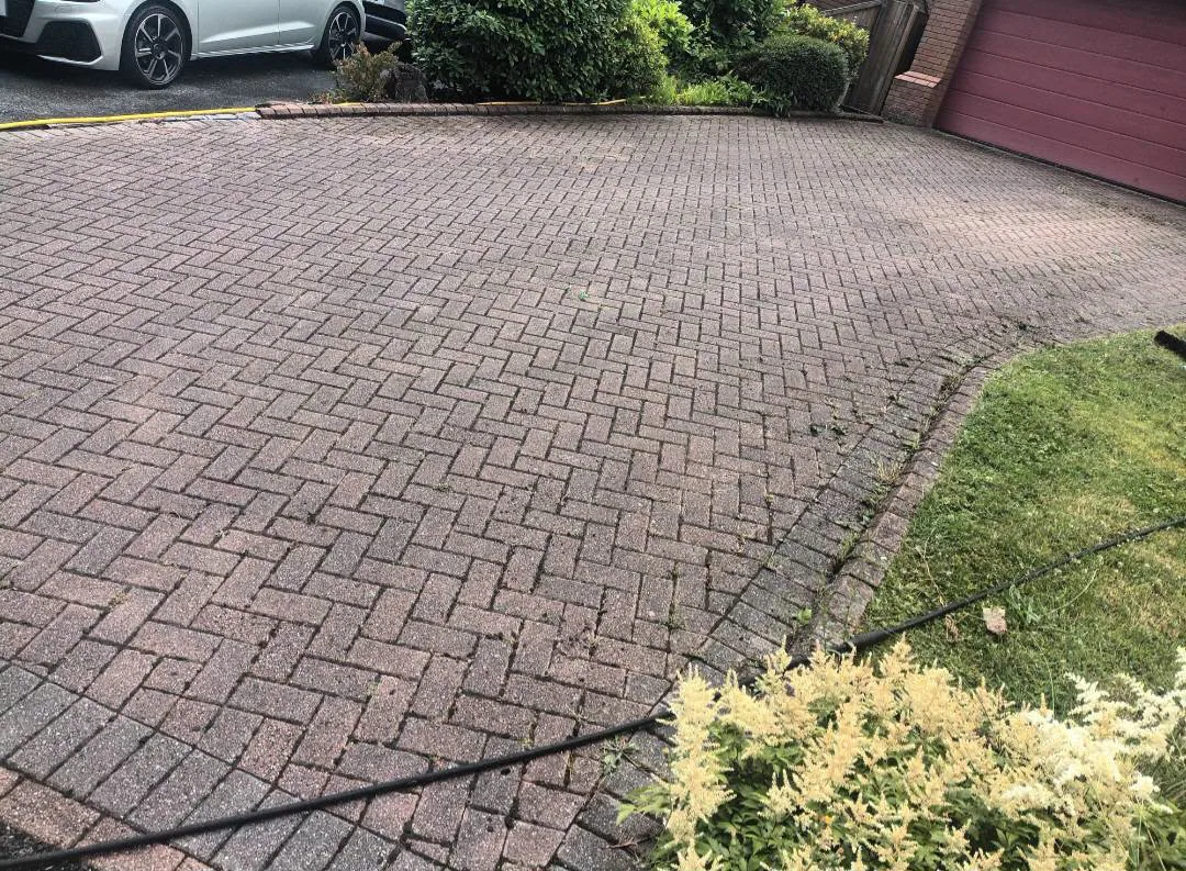 Dark weathered driveway before exterior cleaning