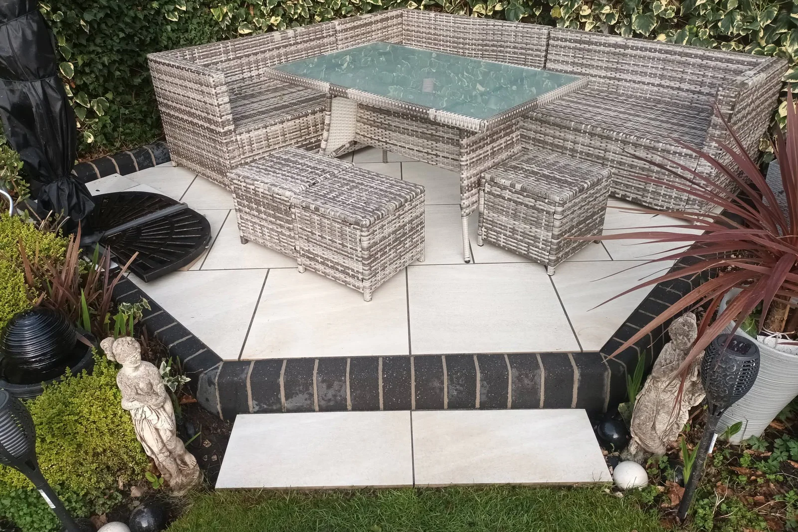 Clean tiled patio with grey outdoor seating and dining furniture
