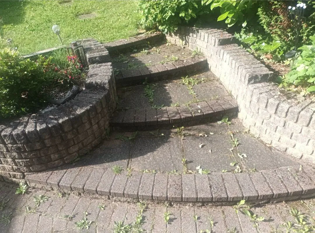 Weathered curved patio steps and paving before exterior cleaning